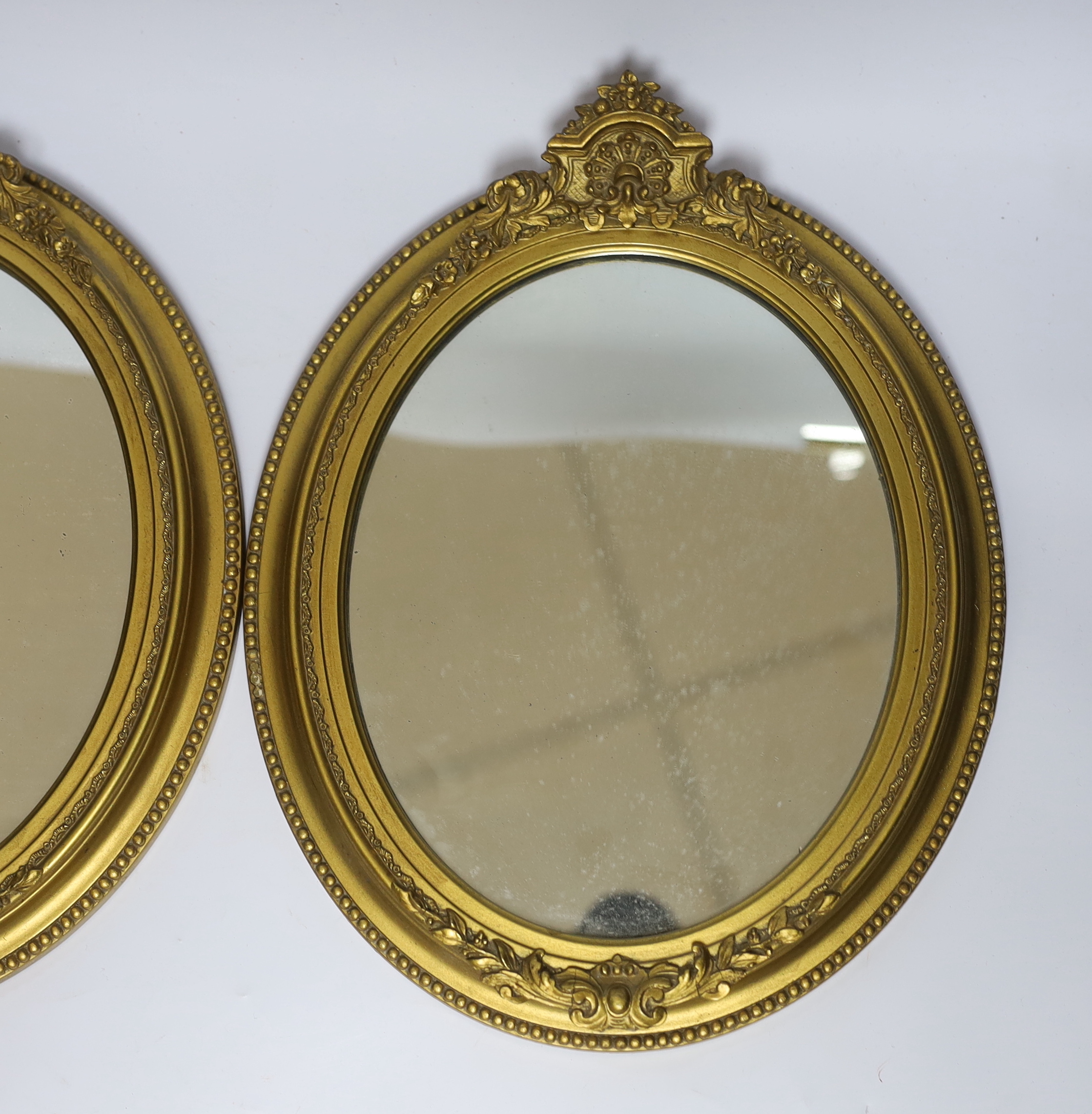 A pair of small oval giltwood and composition wall mirrors, 35cm high
